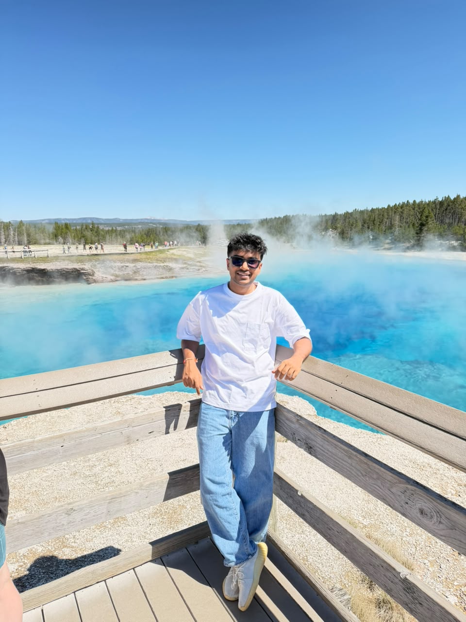 Dev Mehta at a bright blue geothermal spring in Yellowstone